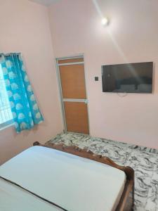 - une chambre avec un lit et une télévision à écran plat dans l'établissement Lagnalaya- Your Next Home, à Rajgir