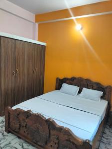a bedroom with a wooden bed with a wooden cabinet at Lagnalaya- Your Next Home in Rājgīr