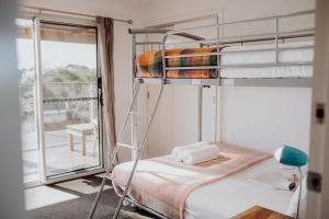1 dormitorio con 2 literas y balcón en Seymour Waves ~ Absolute Serenity, en Bicheno