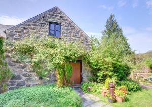 an old stone cottage with a wooden door at Coach House in Llanfachreth