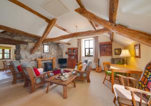 a living room with a fireplace and wooden beams at Coach House in Llanfachreth