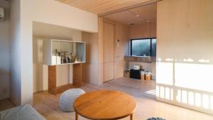 a living room with a wooden table and a chair at 竹田まちホテル in Taketa