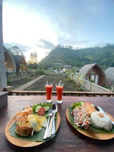 two plates of food and drinks on a table at Batur cottage in Kubupenlokan