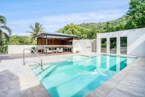 uma piscina no quintal de uma casa em The Orchard House - Luxury Villa on a Sprawling Tropical Acreage em Redlynch