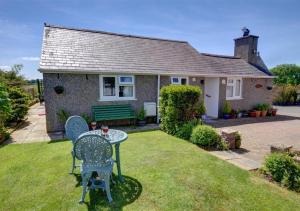 a small house with a table and chairs in the yard at Y Bwthyn in Abererch