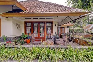 Casa con porche con sillas y casa en Collection O 90461 Graha Atmadja Syariah Guest House, en Bandung