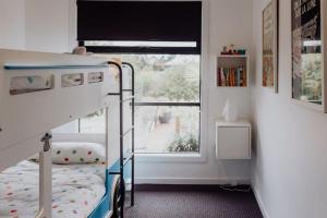 een kleine slaapkamer met een stapelbed en een raam bij Lifebuoy Beach House Bicheno in Bicheno