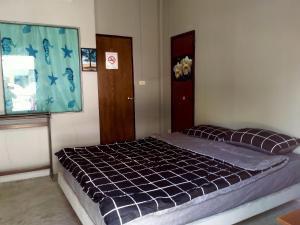 a bedroom with a bed with a blue comforter at หาดริ้นเกสท์เฮาส์ in Haad Rin