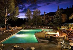 una piscina con mesa y fogata en The Charter 2 Bedroom Ski In, Ski Out Vacation Rental With Hot Tub Access And Easy Walk To Village en Beaver Creek