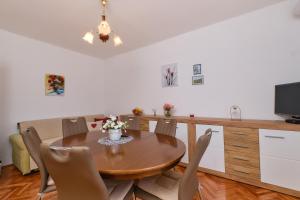 a dining room with a wooden table and chairs at Sea View Apartment Sandra in Mali Lošinj in Mali Lošinj