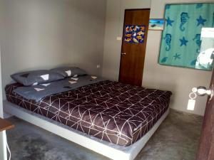 a bedroom with a bed with a brown comforter at หาดริ้นเกสท์เฮาส์ in Haad Rin +8 photos