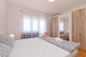 a bedroom with a white bed and a window at Sea View Apartment Sandra in Mali Lošinj in Mali Lošinj