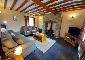 a living room with a couch and a tv at Llwyniarth in Dolgellau