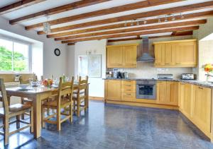 a kitchen with wooden cabinets and a table and chairs at Llwyniarth in Dolgellau