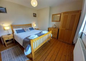 Schlafzimmer mit einem Bett und Holzboden in der Unterkunft Llwyniarth in Dolgellau