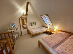 een slaapkamer op zolder met 2 bedden en een raam bij KULTURGUTLEBEN Boutiquehotel Seminarhaus in Möllenbeck