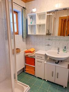 a white bathroom with a sink and a shower at Chalet Faschingalm in Debant