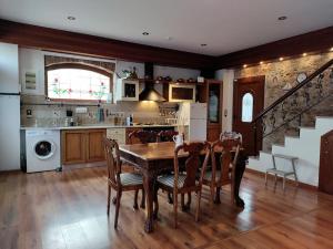 a kitchen with a table and chairs and a staircase at Zografia cottage in Lámpou Mýloi