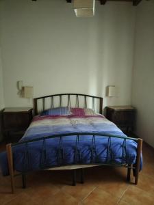 Bett in einem Zimmer mit zwei Nachttischen in der Unterkunft Rod Ranch Livestock - Stanza matrimoniale in clubhouse in Campagnano di Roma