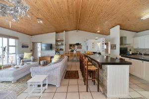 a kitchen and living room with a table and chairs at Oceanview House in Struisbaai