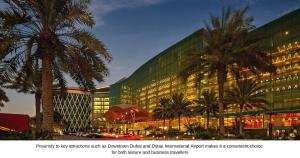 a large building with palm trees in front of it at The Meydan Hotel Dubai in Dubai