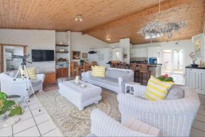 sala de estar con muebles blancos y cocina en Oceanview House, en Struisbaai