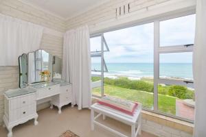 baño con ventana grande con vistas al océano en Oceanview House, en Struisbaai
