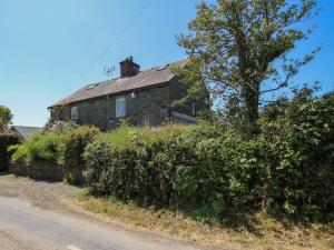 an old stone house on the side of a road at 1 Hetfield Cottages in Bishops Castle