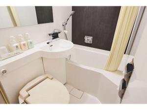 bagno con servizi igienici bianchi e lavandino di Urayasu Sun Hotel - Vacation STAY 33007v a Urayasu