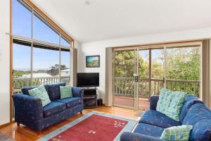 a living room with two blue couches and a television at 38 Bayview Drive in Cowes