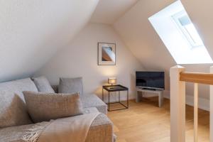 a living room with a couch and a tv at Reetdachhaus Dünen Lounge in Böhl