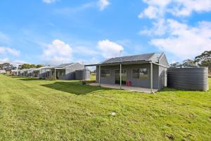 une rangée de maisons modulaires dans un champ dans l'établissement Glenowrie Cottage - 1 King 2 Singles - Near Cadia, à Millthorpe