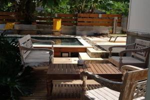 een patio met 2 stoelen, een tafel en een zwembad bij bungalow avec piscine chauffée. in Saint-Joseph