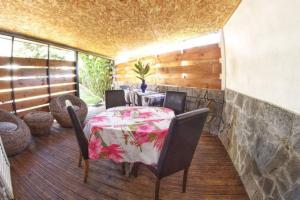 comedor con mesa y sillas en el porche en bungalow avec piscine chauffée., en Saint-Joseph