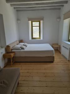 una camera con un grande letto e una finestra di Aviola Mykonos a Ftelia