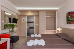 a bedroom with a bed with towels on it at Atrion Resort Hotel in Agia Marina Nea Kydonias