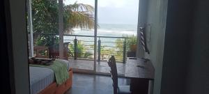 a bedroom with a view of the ocean from a balcony at Toddy by windy in Unawatuna