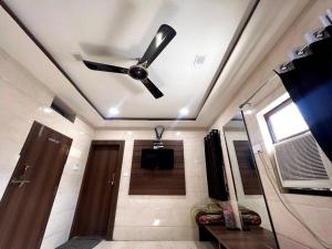 a ceiling fan in a living room with a television at Hotel Ajmer in Ajmer