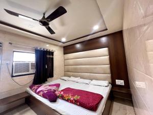 a bedroom with a bed and a ceiling fan at Hotel Ajmer in Ajmer