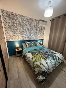 una camera da letto con un letto con una parete con accenti floreali di La Case Baies Roses - Maison F2 a Saint-Denis