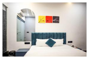 een slaapkamer met een bed met een blauw hoofdeinde en een spiegel bij HOTEL THE PARKER INN By KBNT GROUP in Surat