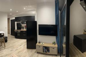 a living room with a flat screen tv on a wall at La Case Baies Roses - Maison F2 in Saint-Denis