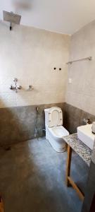 a bathroom with a toilet and a sink at Jacaranda Tree Garden in Pātan