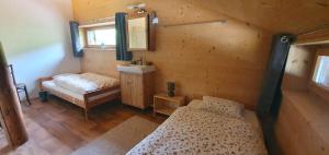 niewielka sypialnia z 2 łóżkami i lustrem w obiekcie Chalet Chanso w mieście Morgins