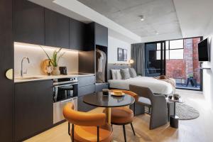 a kitchen and living room with a bed and a table at Veriu Collingwood in Melbourne