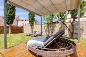 a hammock on a deck under a large umbrella at Holiday house "Laurus Garden" with private parking in Medulin