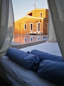 a bed with blue pillows in a room with a window at Casa rural isleña in Sant Francesc Xavier