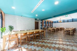 una sala da pranzo con tavoli e sedie in legno di Qun Xiang Hotel ad Anping