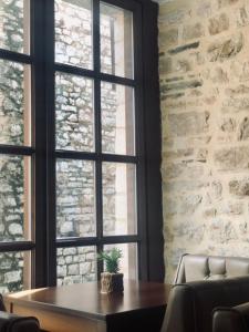 une table avec une plante en pot devant une fenêtre dans l'établissement Ali Pasha Hotel, à Ioannina