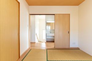 a hallway with a door and a rug at ザ・ヴィラス待遠屋 in Bise